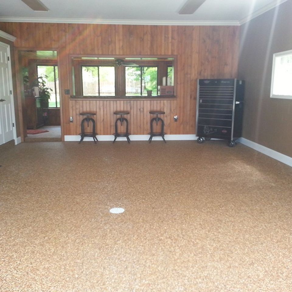Spacious finished basement with an EverStone decorative stone floor in a warm earth-tone blend.