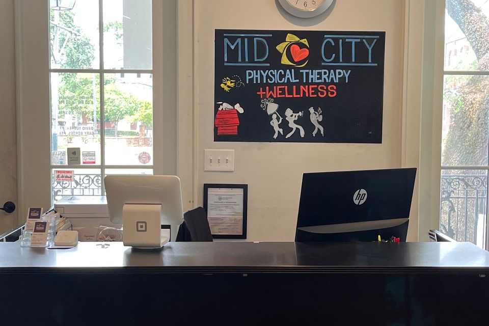 Front desk with signage at Mid City Physical Therapy in New Orleans.