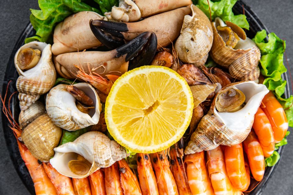 A variety of seafood including, crab claws, clams, shrimp, rapan and others on a plate from the top view