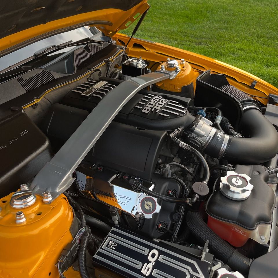 Ford Mustang Boss 302 engine bay with polished caps and strut tower brace after engine bay detailing