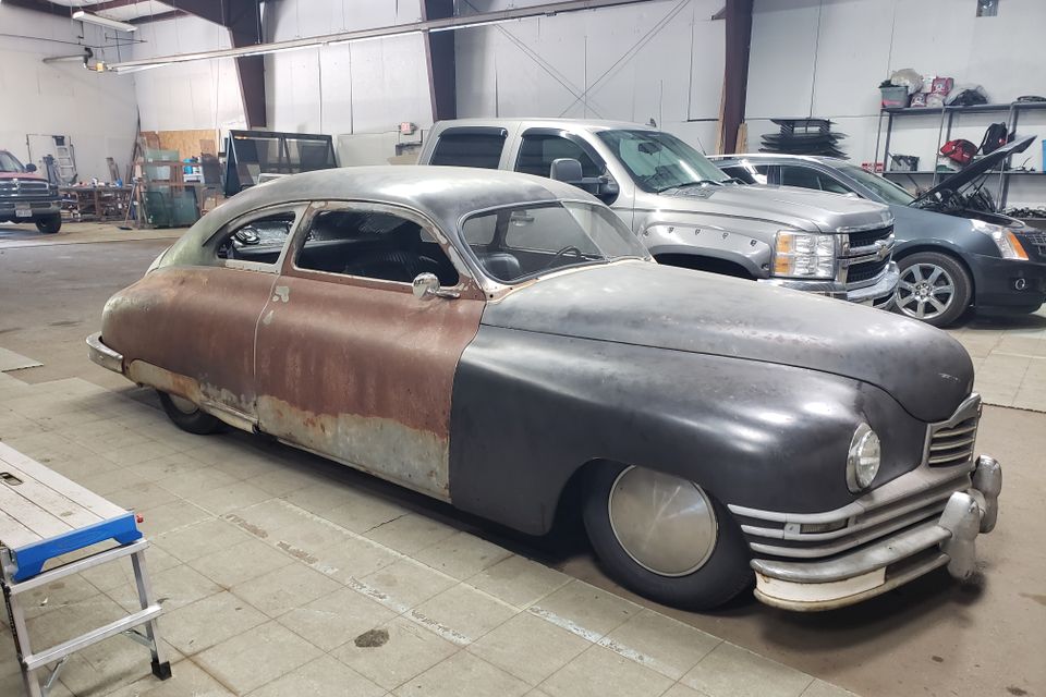 Classic custom vehicle inside an auto glass shop receiving specialty glass repair and replacement services.