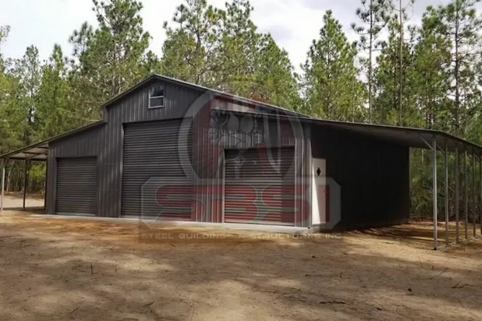 Dark gray steel barn with side lean to in pine wooded lot with SBSI watermark representing steel barns in Alabama
