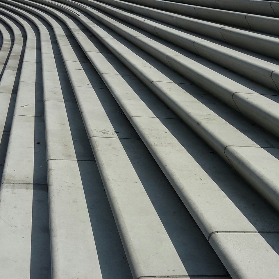 Architectural curved cement stairway and reinforced masonry steps designed for a high-traffic commercial building entry by Roseville Concrete Solutions