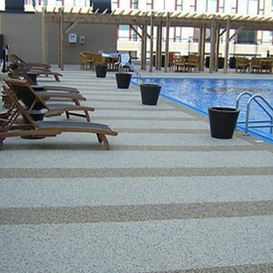 Pool deck with EverStone Flex flooring and lounge chairs alongside the swimming pool.