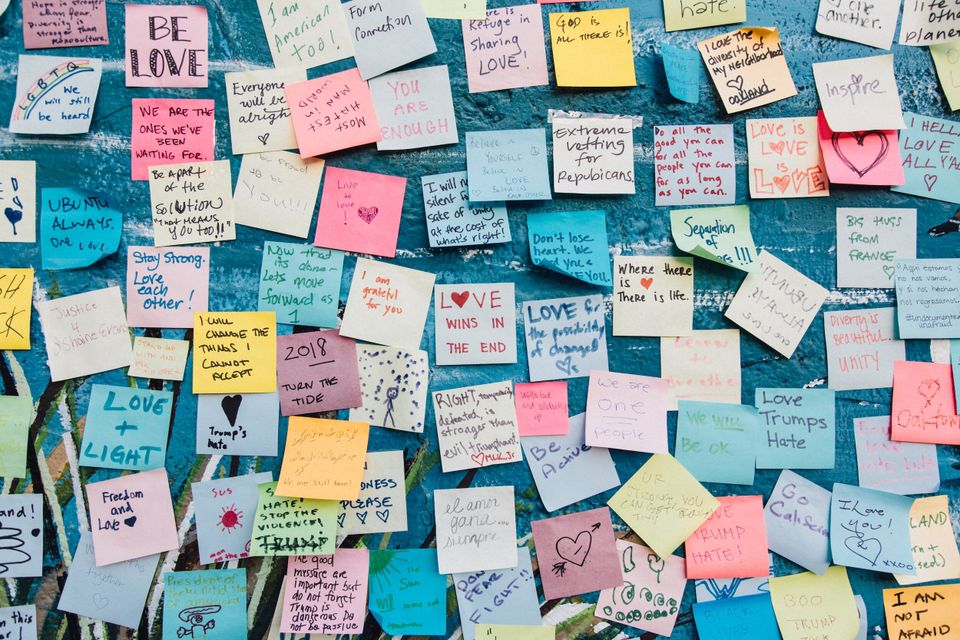 A wall full of post its with encouragement on them 