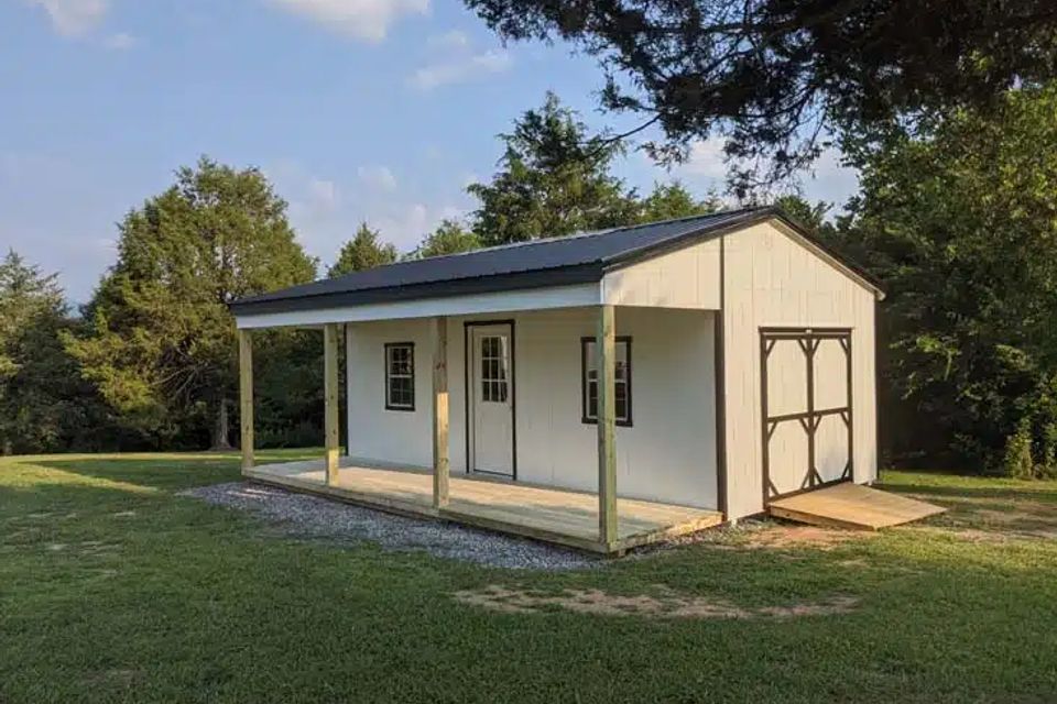 White country cabin with full length covered porch and side barn doors in Elizabethton TN