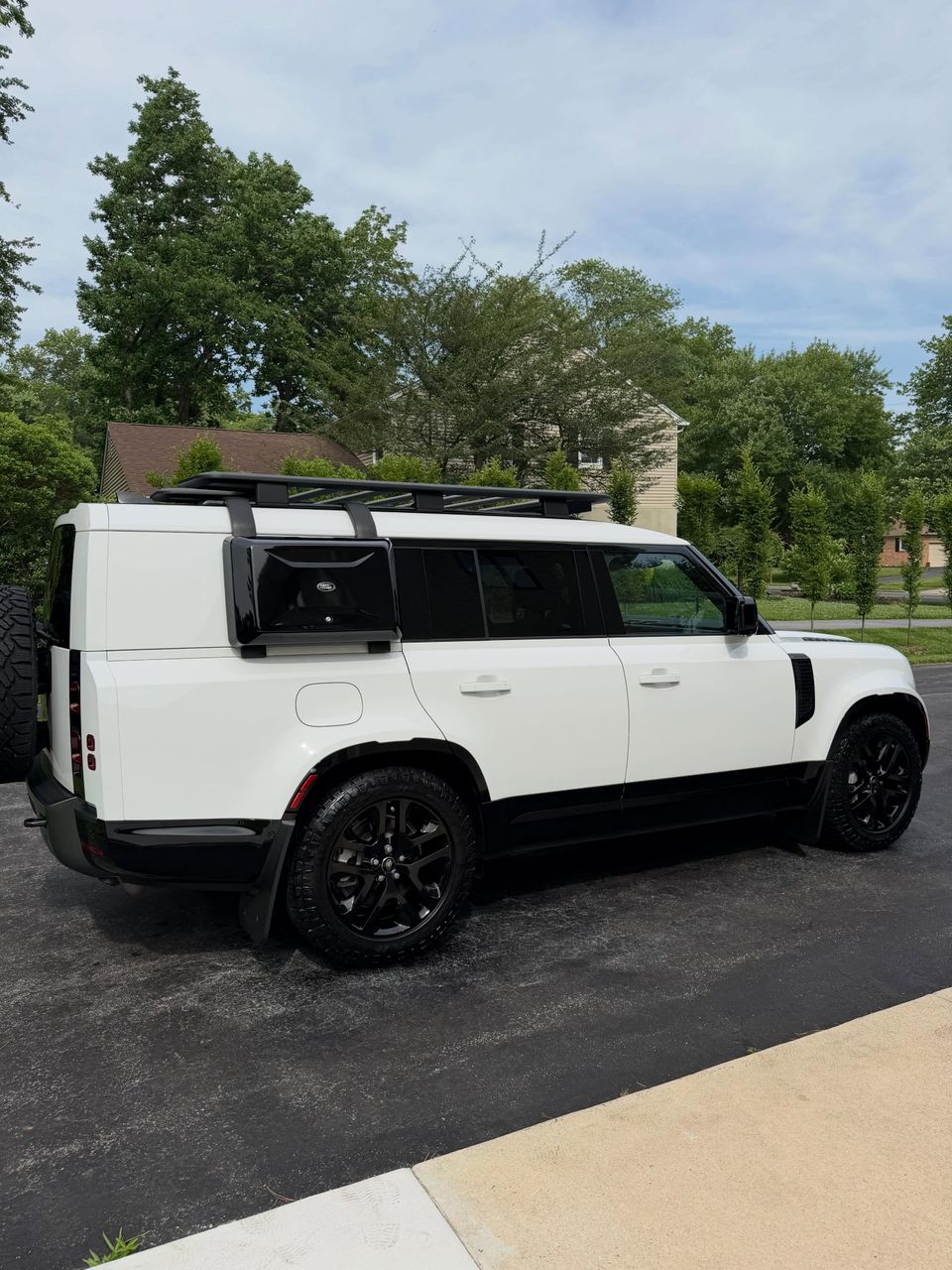 White Land Rover Defender 130 with roof rack shining after a mobile exterior detail in Wilmington