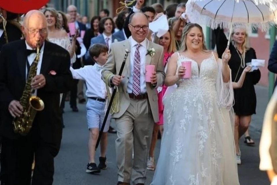 Bride and groom leading a New Orleans second line parade during a Carpe Diem Events wedding welcome party