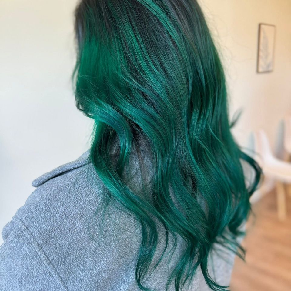 Dark hair with vibrant emerald green color and soft waves after color service in Columbiana AL