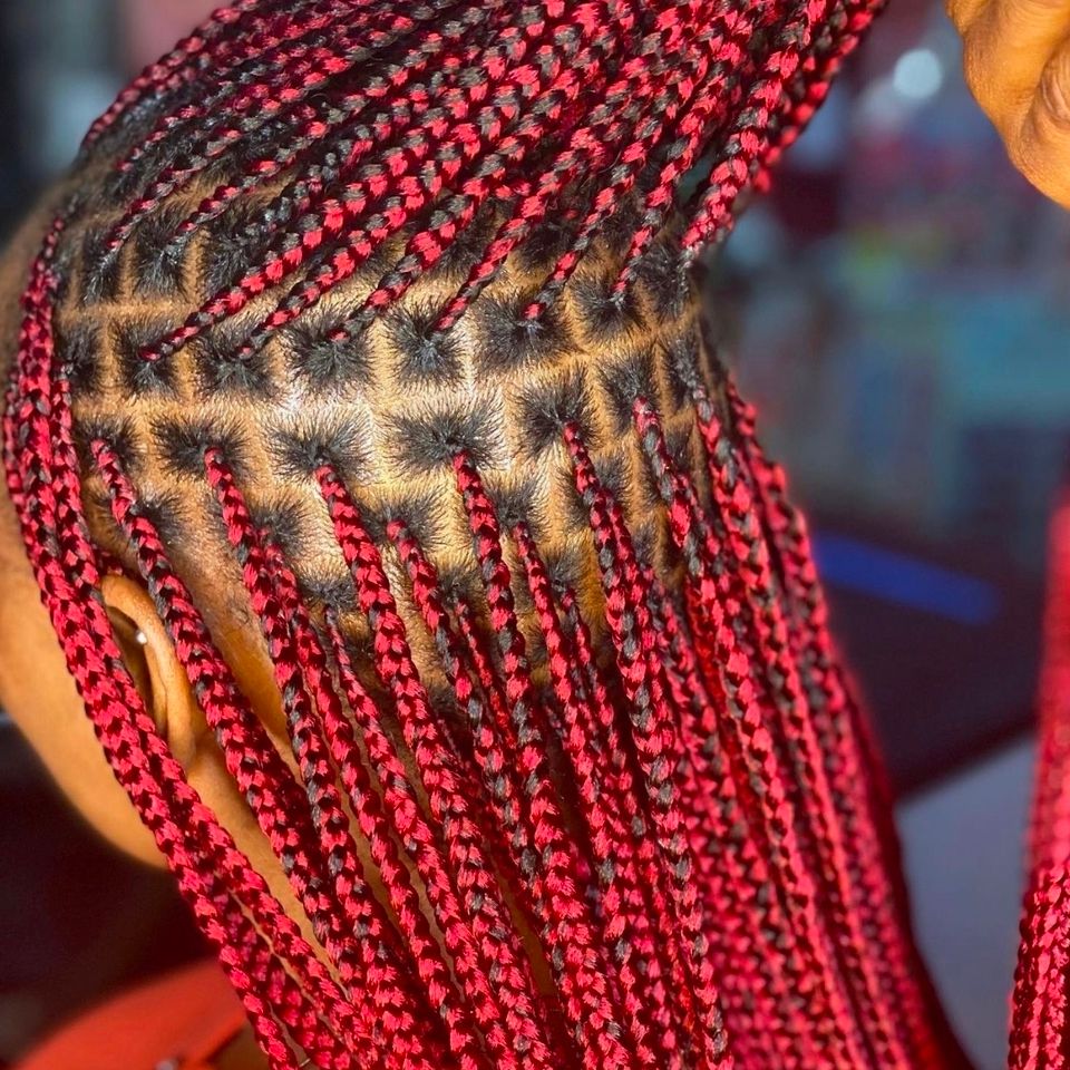 Close up of neatly parted red knotless box braids after a braiding service in Los Angeles CA