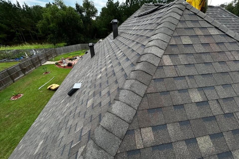A worker putting the finishing touches on a roof by Teal Roofing in Walker, LA.