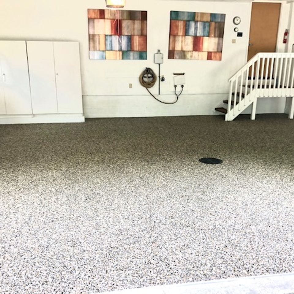 Residential garage featuring EverStone Epoxy Stone flooring with a decorative natural stone finish and seamless installation.