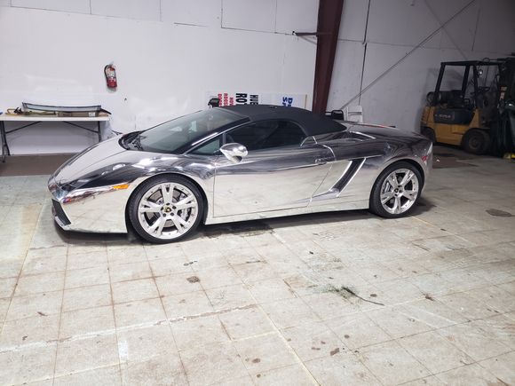 Luxury convertible inside an auto glass shop for specialty custom glass installation and replacement.