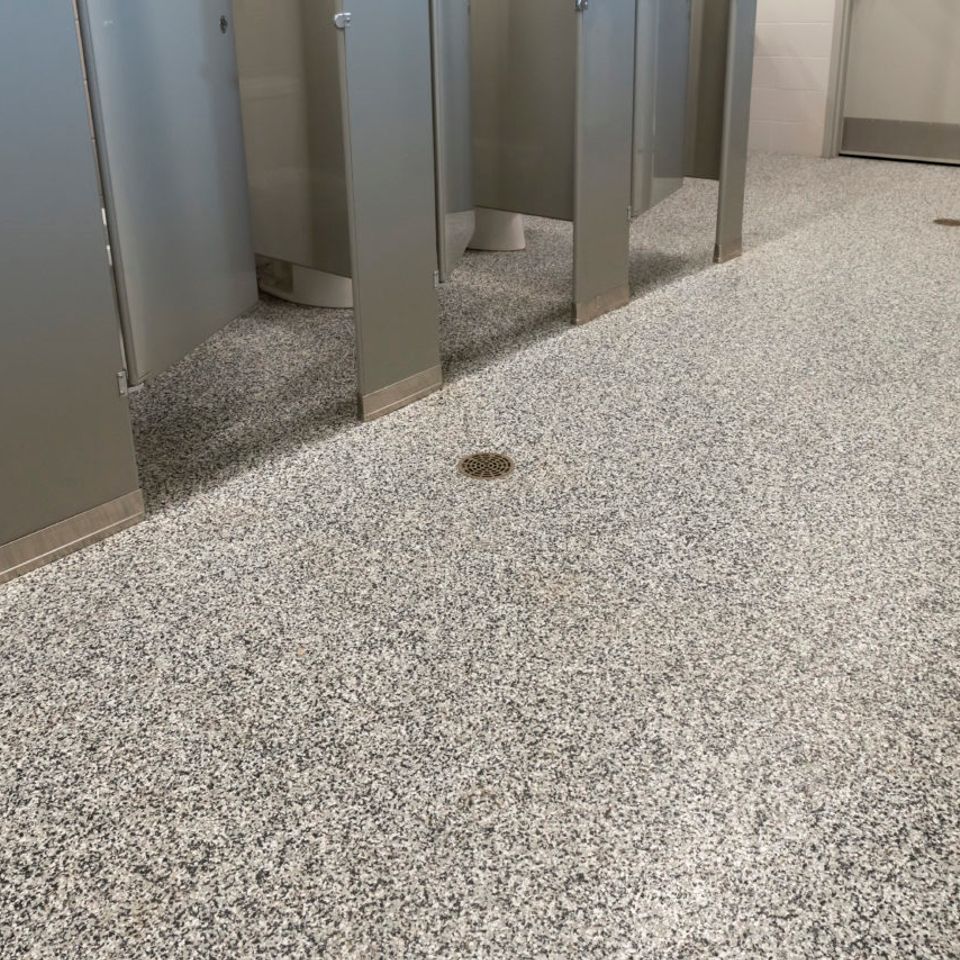 Restroom with EverStone Flakes flooring and stall partitions.