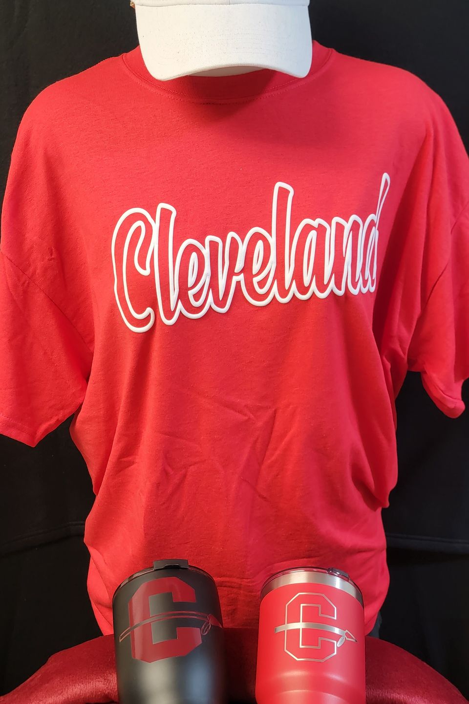 Example of Direct to Film (DTF) transfer - alternate Cleveland HS logo on a red t-shirt, embroidered logo cap, and tumblers. 