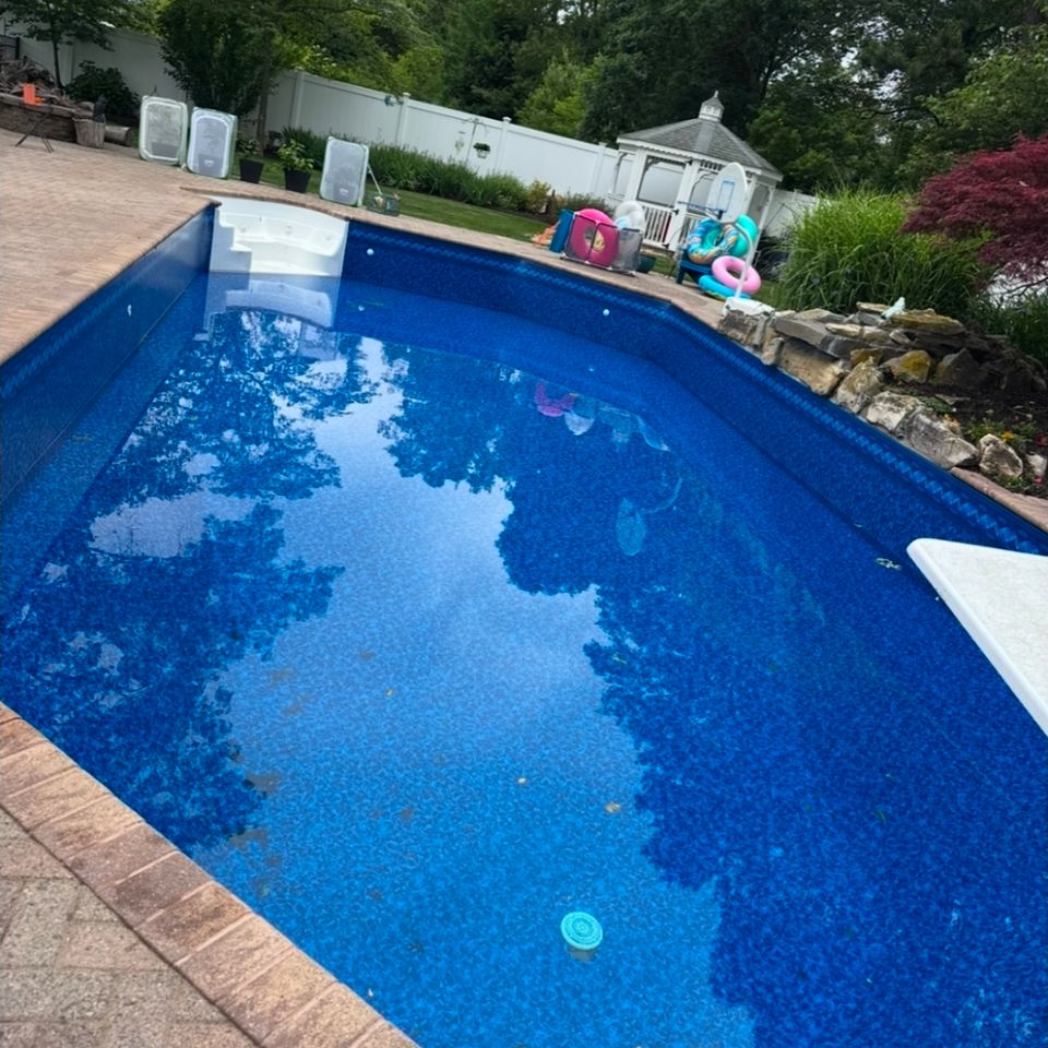Inground pool with new liner, tile border, and diving board filled after a liner replacement in Long Island NY