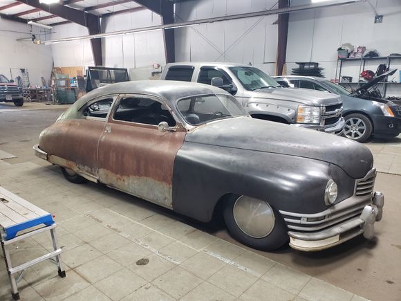 Classic custom vehicle inside an auto glass shop receiving specialty glass repair and replacement services.