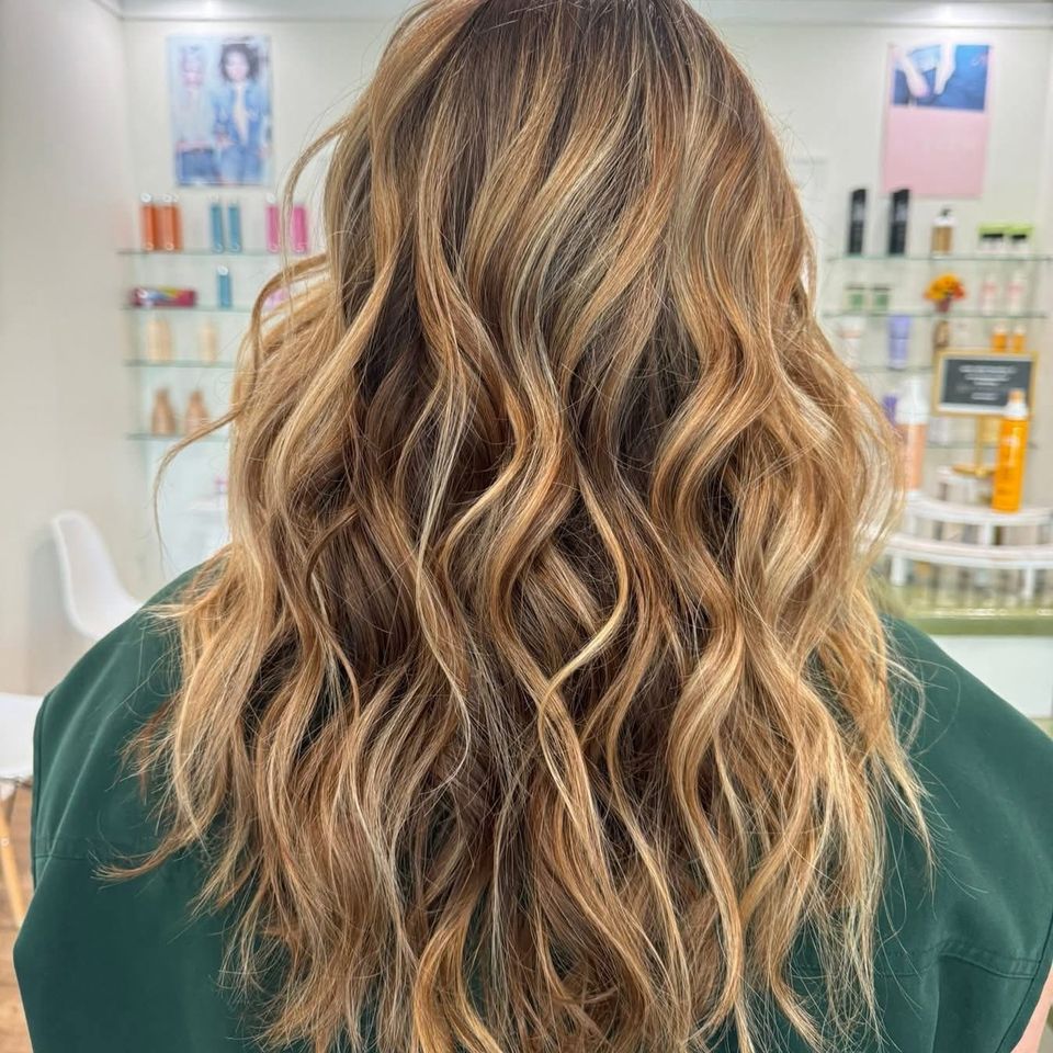 Long wavy caramel balayage with blonde highlights after color service in Columbiana AL