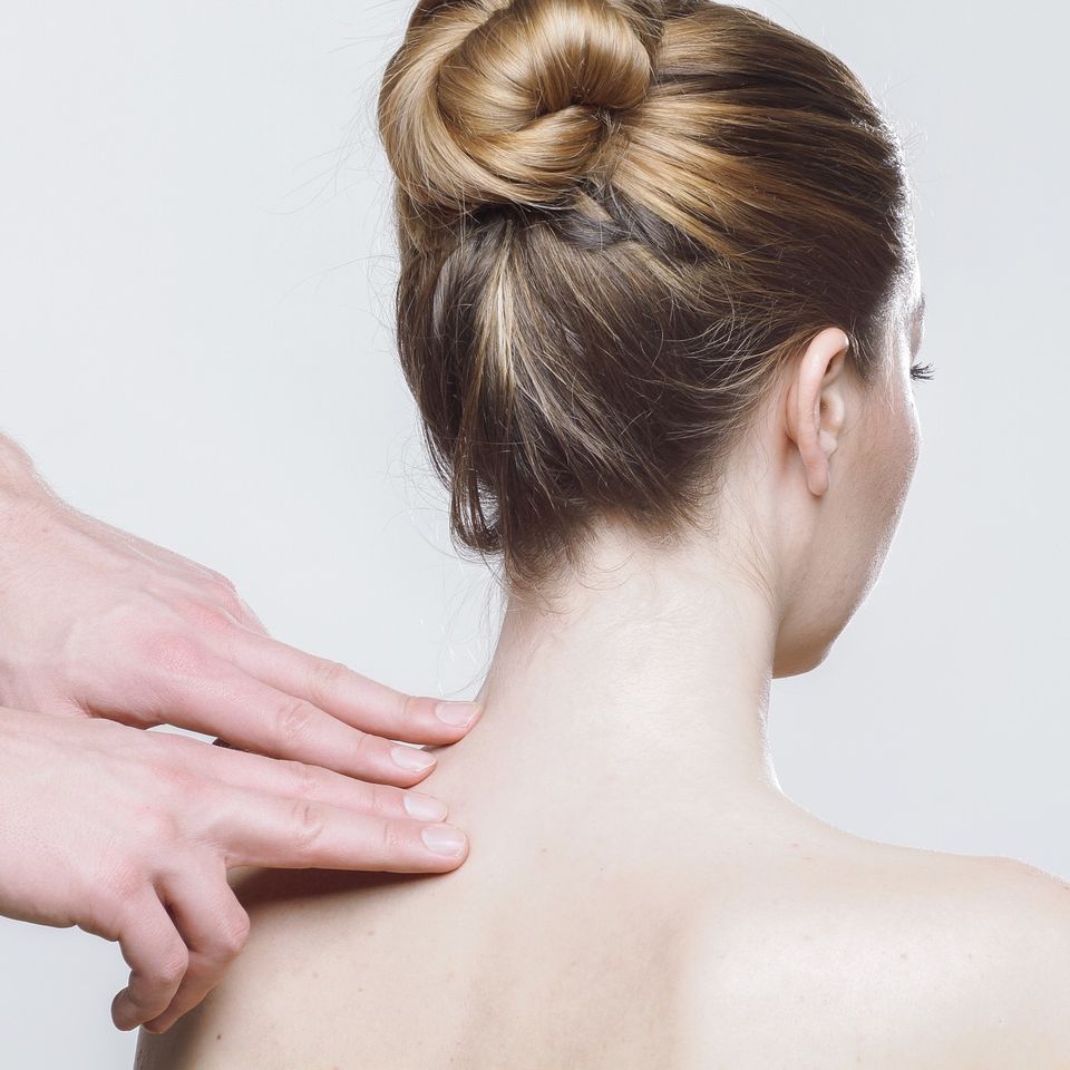 Chiropractor performing a manual neck assessment during a chiropractic treatment session.