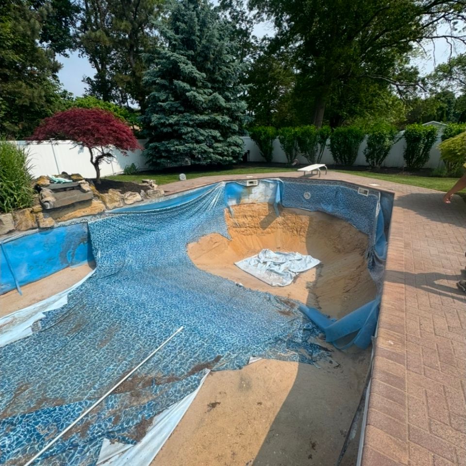 Old faded pool liner pulled back for liner replacement at a Long Island NY backyard pool