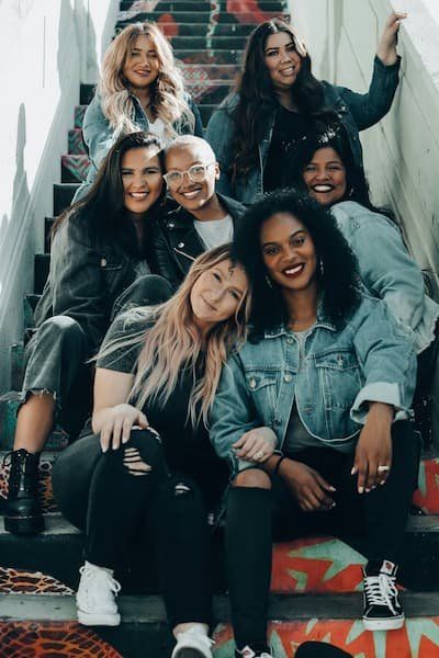 A diverse group of women all sitting on the stairs 