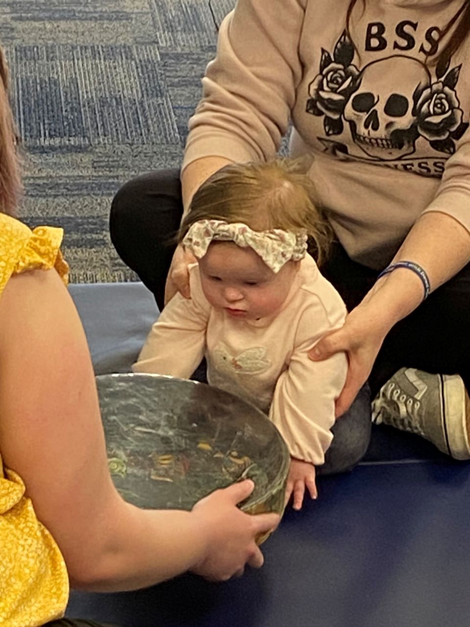 Infant participating in a sensory activity with caregiver support during a Down Syndrome Association of the Valley early childhood program.