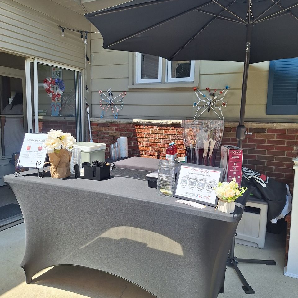 Full bar setup with mixers, garnishes, and decor for a baby shower event