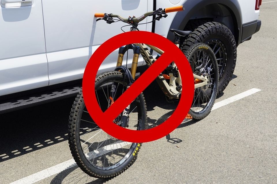 Mountain bike leaning against car