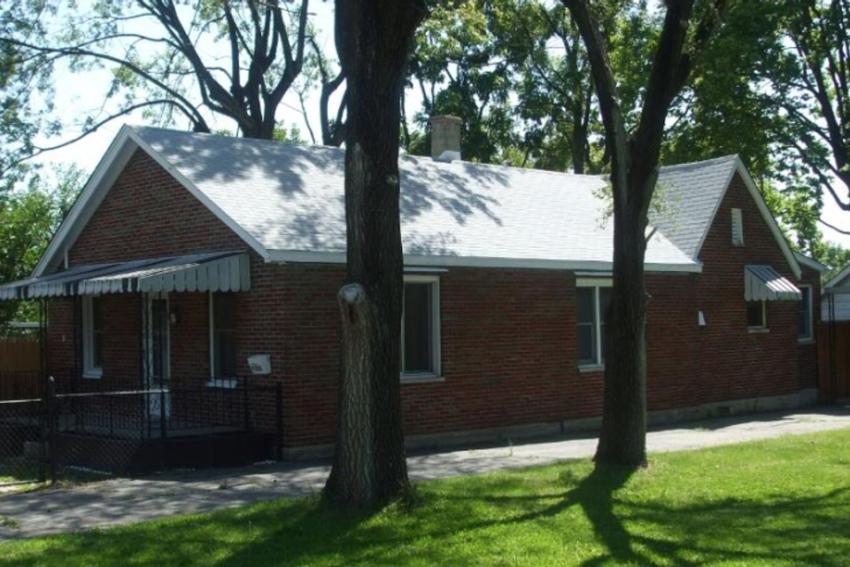 Brick home with a newly installed asphalt shingle roof completed by E & D Roofing, Inc.