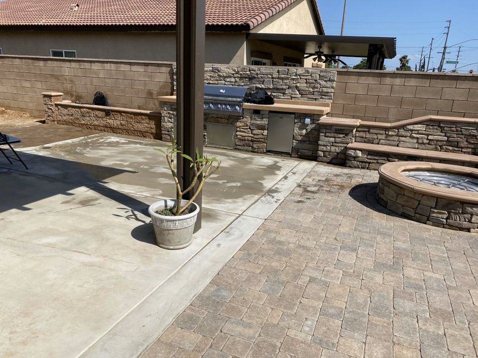 Backyard paver patio with built-in fire pit, outdoor kitchen, and decorative seating wall