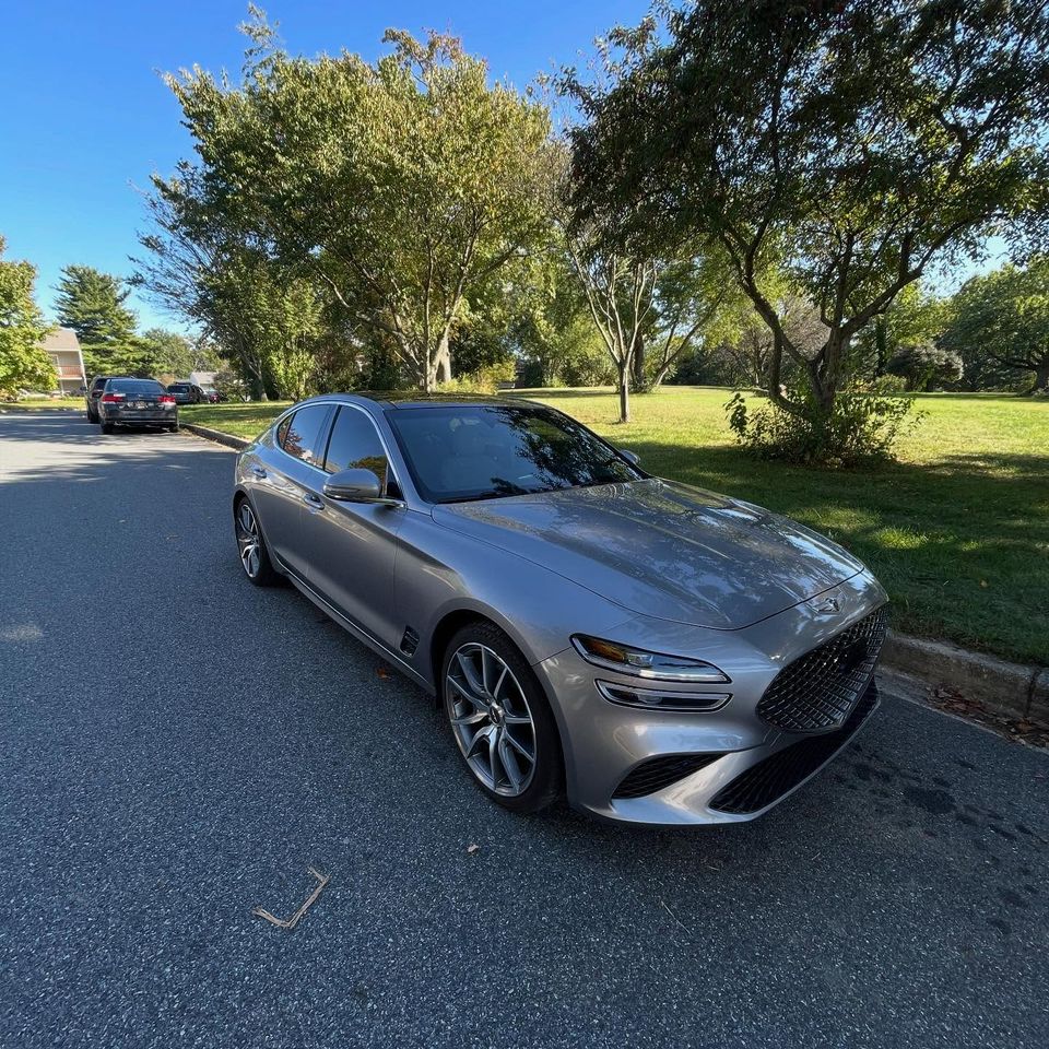 Silver Genesis G70 sedan with a reflective gloss finish after exterior cleaning on a tree-lined Wilmington street