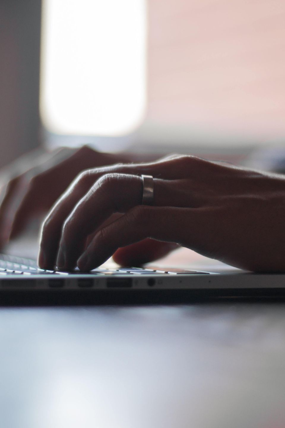 Hands typing on keyboard, blurry background