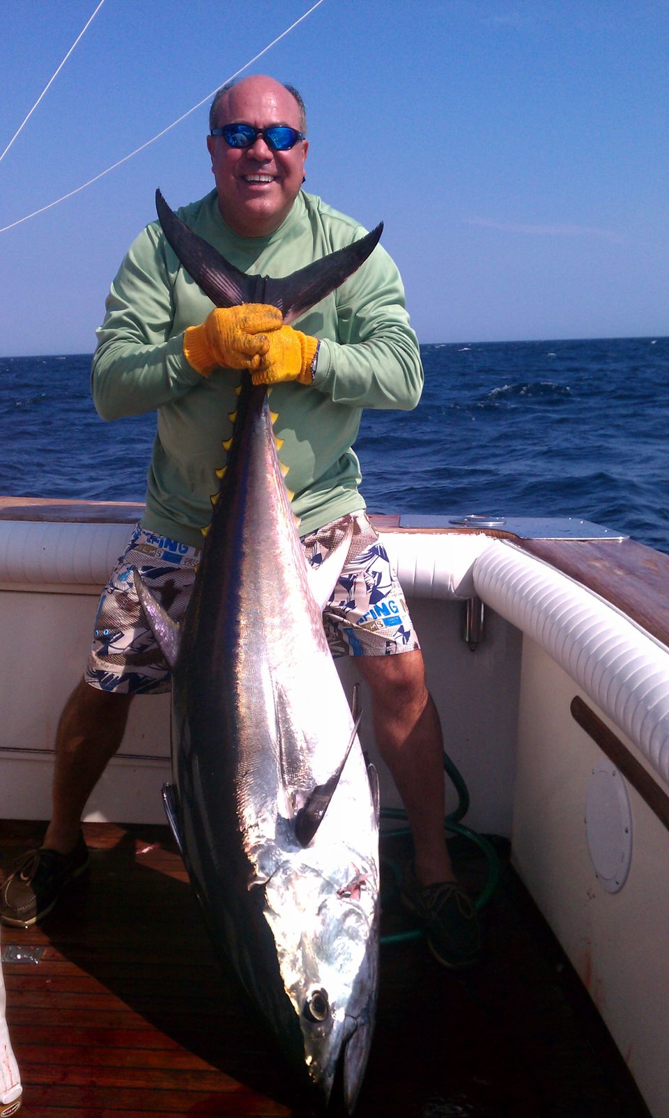 Man on boat holding tuna