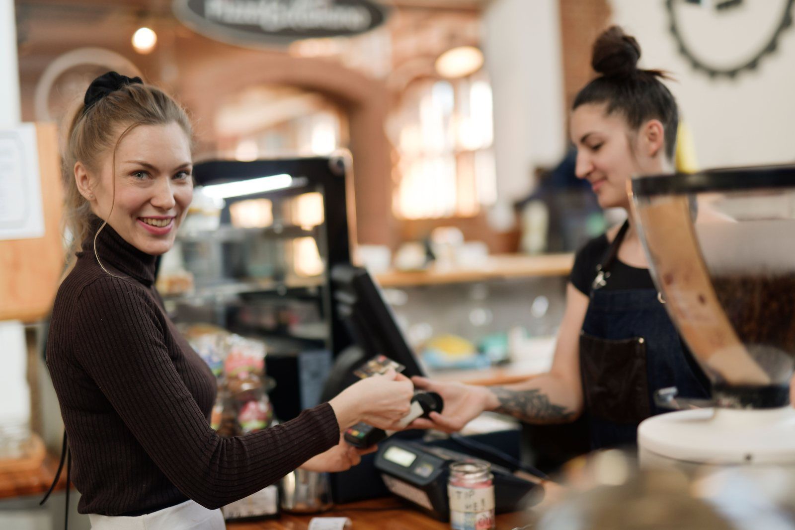 Customer paying at a cafe checkout counter, where loyalty points can be earned