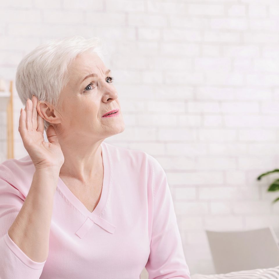 Age-related hearing loss, symptoms. Senior woman listening for something at home