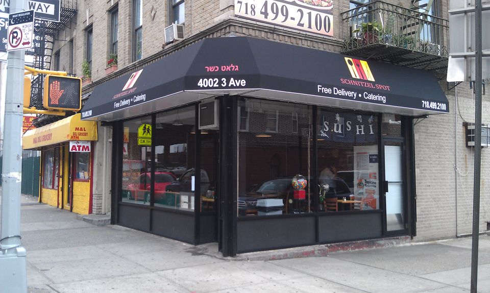 Black corner awning wrapping two sides of the storefront.