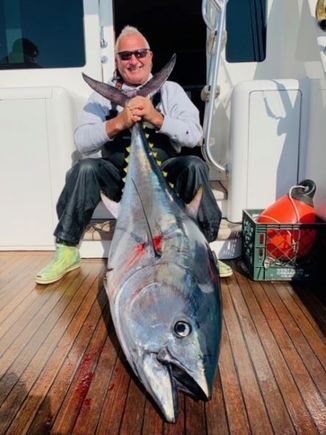 Capt stan sitting on boat holding bluefin tuna
