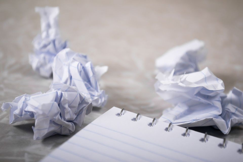 Crumpled up paper surrounding a notebook