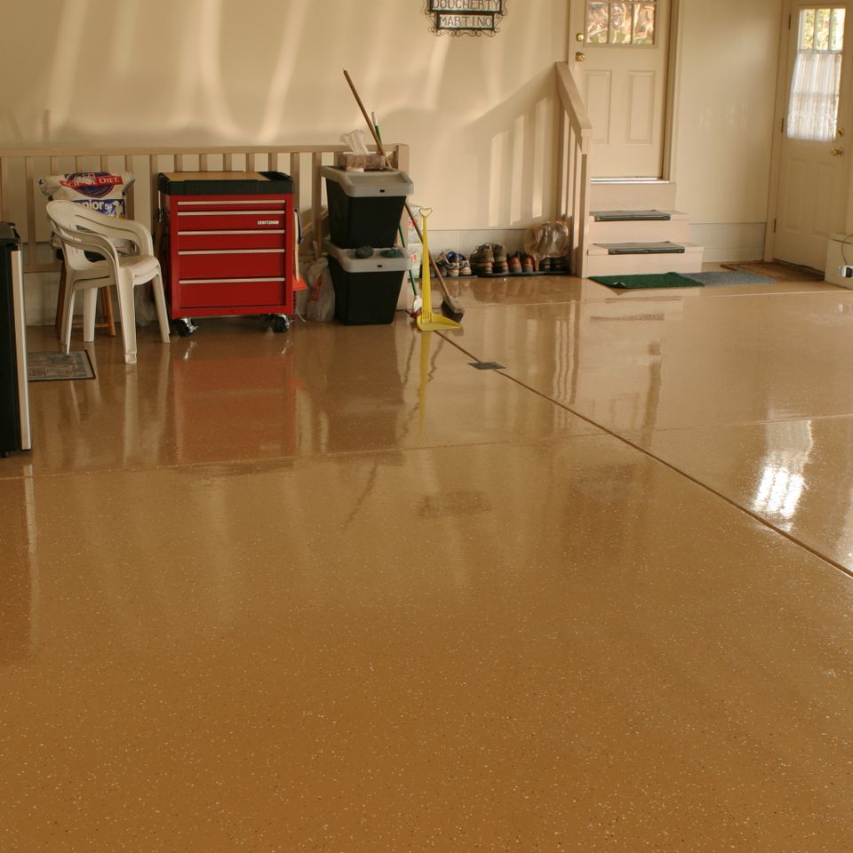 Residential garage with a glossy tan epoxy floor coating designed for durability and easy maintenance.