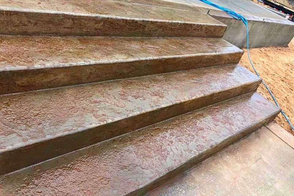 Custom tan earth-tone masonry steps and decorative backyard stairway integrated into a residential landscape design by Roseville Concrete Solutions.