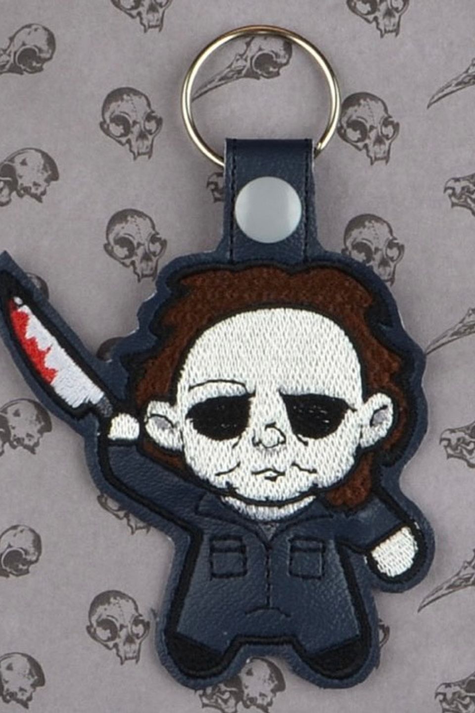 Custom embroidered horror-themed keychain featuring a masked character holding a knife.