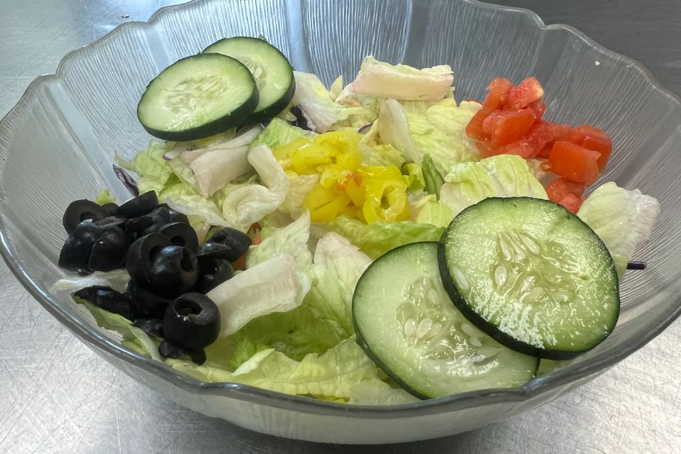 Garden Salad with lettuce, cucumbers, tomatoes, black olives, peppers, and cheese at Cocca’s Pizza.