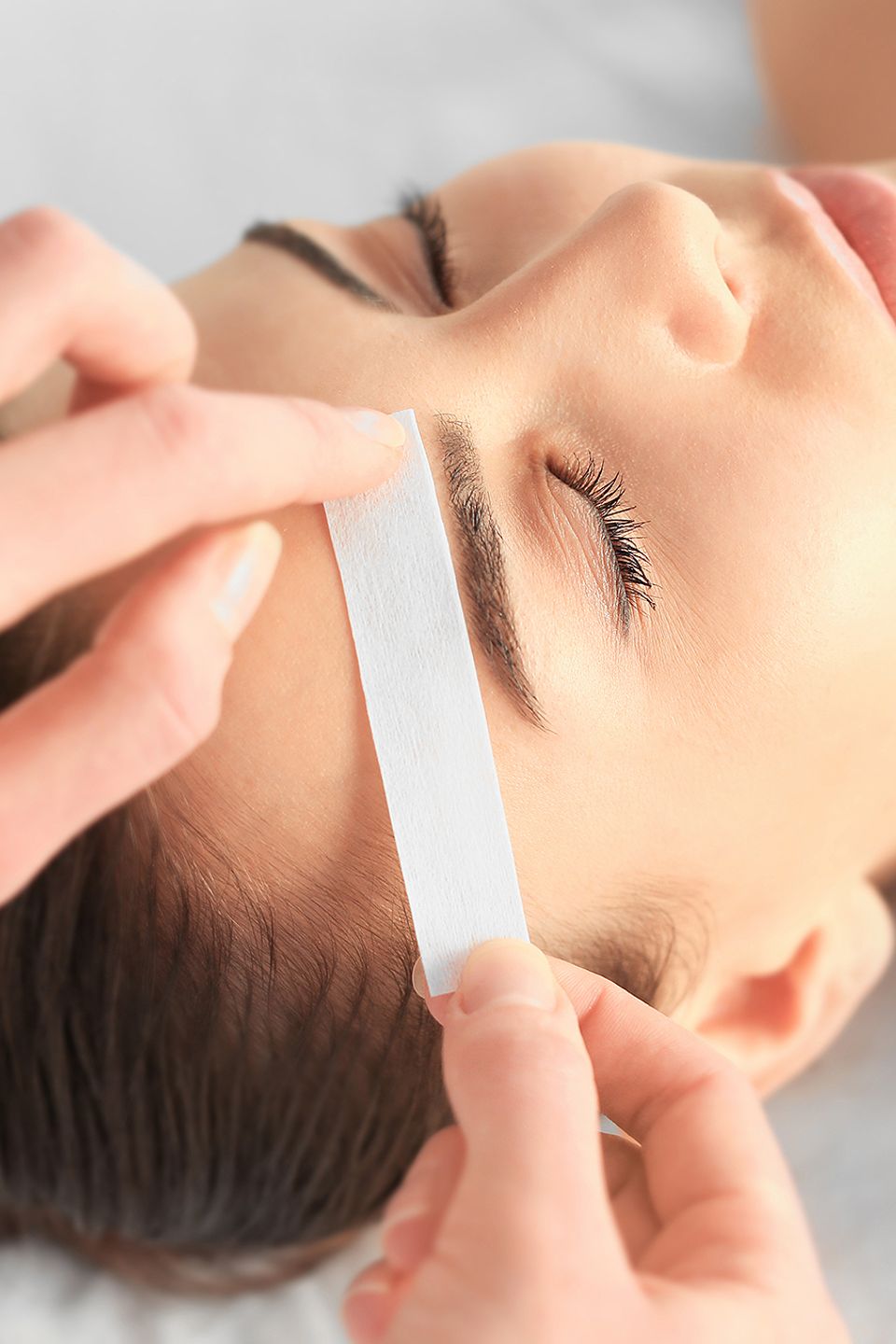 Student performing eyebrow treatment