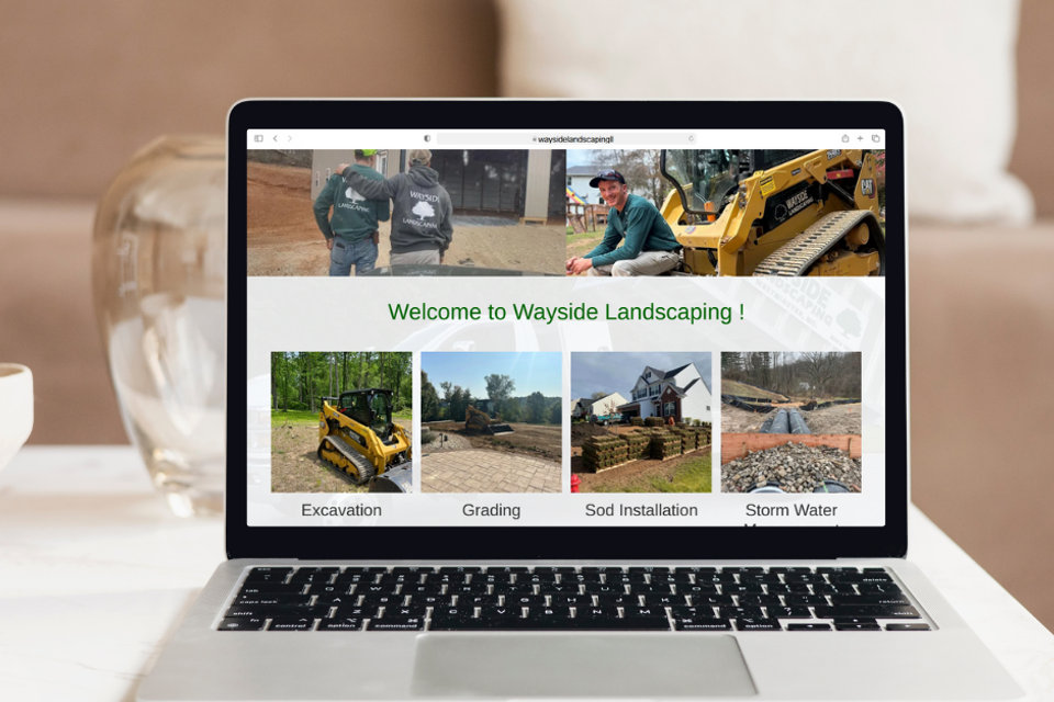 Wayside Landscaping website on laptop screen showing excavation, grading, sod installation, and stormwater services in Westminster Maryland.