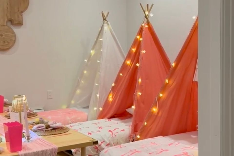 Indoor sleepover party setup with lighted teepee tents and a low styled table in a Hamptons NY home