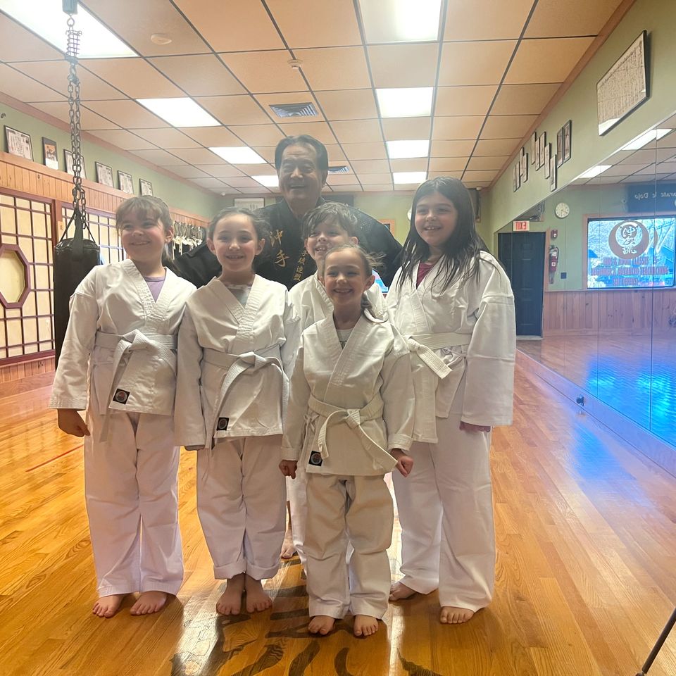 Hanshi Takamine and the kid karate students, posing for a photo