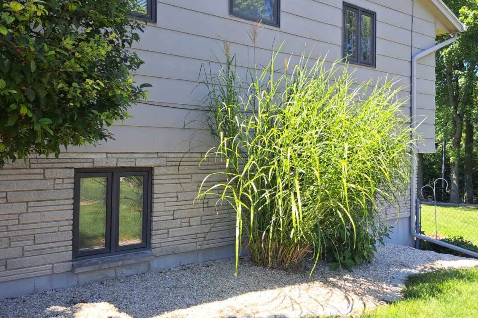 Decorative gravel landscaping surrounding a home's foundation with ornamental grasses.