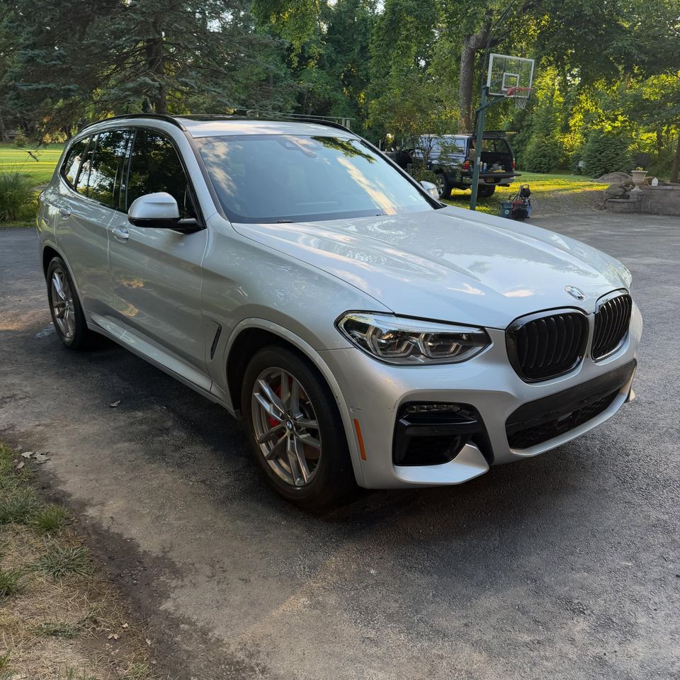 Silver BMW X3 M Sport with red calipers and a clean gloss finish after a driveway detail in Wilmington Delaware