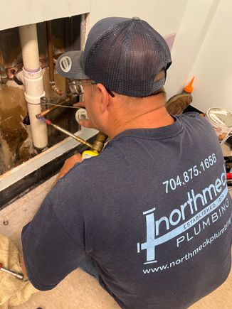 Kenny working with alec at school fixing pipe for sink