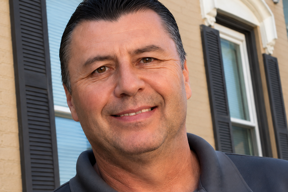 Smiling man by beige brick facade